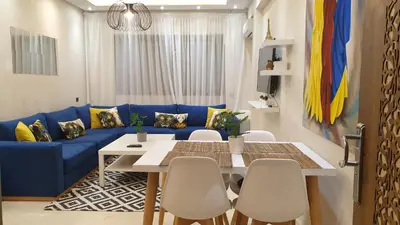 a living room with a blue couch and a table and chairs at Apparemment yasmina in Marrakech