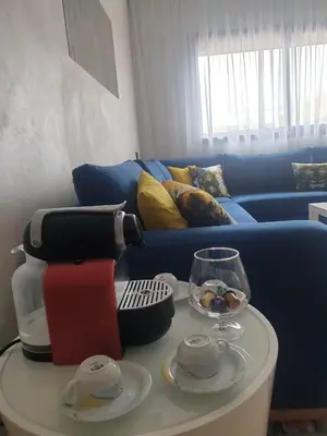 a coffee table with a juicer and a blue couch at Apparemment yasmina in Marrakech