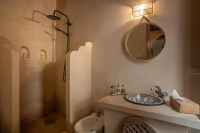 a bathroom with a sink and a mirror and a shower at Riad Tassili Marrakech in Marrakech