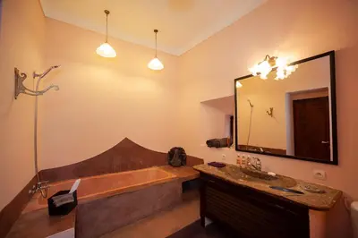 a bathroom with a tub and a large mirror at Dar Le Fennec in Marrakech