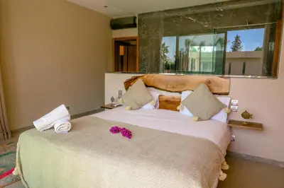 a bedroom with a large bed with pink flowers on it at Villa des sœurs bradaa in Marrakech