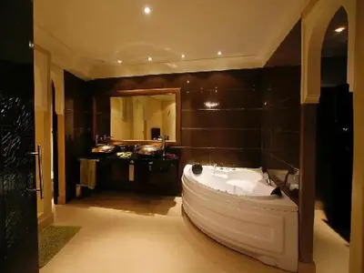a large bathroom with a large tub and a large mirror at Riad Carllian in Marrakech