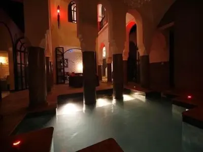 an empty room with columns and lights in a building at Riad Carllian in Marrakech