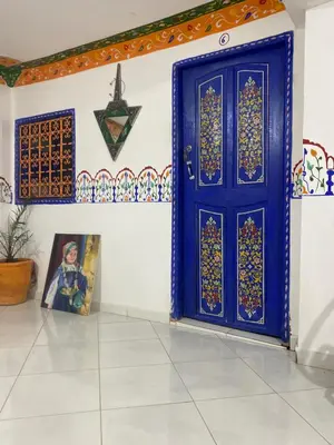 a blue door in a room with a picture at Hostel Essassi 23 in Marrakech