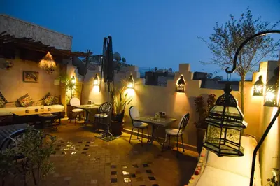 an outdoor patio with tables and chairs at night at Riad Vis Ta Vie in Marrakech