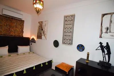 a bedroom with a bed and some pictures on the wall at Riad Vis Ta Vie in Marrakech
