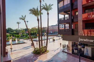 a shopping mall with palm trees in a city at Appartement Haut Standing Gueliz Plaza avec Vue in Marrakech
