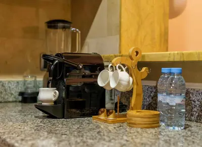 a kitchen counter with a coffee maker and cups at Appartement Haut Standing Gueliz Plaza avec Vue in Marrakech