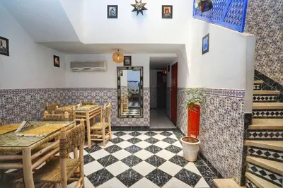a restaurant with a table and chairs and a mirror at Riad Amirkesh and Pool in Marrakech
