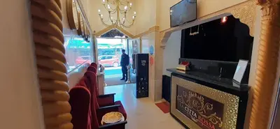 a room with chairs and a tv and a mirror at Hôtel La Citta Rossa in Marrakech
