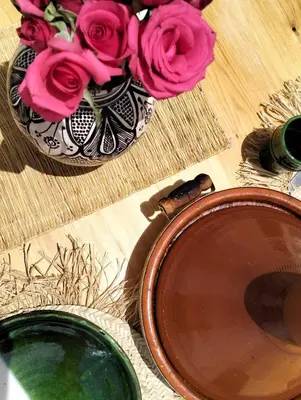 a vase filled with pink roses sitting on a table at Riad Siena II in Marrakech