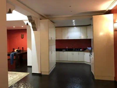 a kitchen with white cabinets and a red wall at Riad luna in Marrakech
