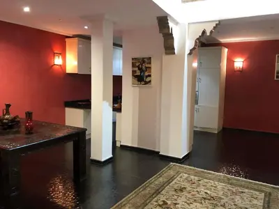 a living room with red walls and a table with a rug at Riad luna in Marrakech