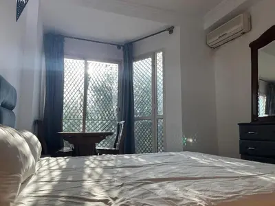 a bedroom with a bed and a window and a table at Perfect only family apartment & air cooling in Marrakech