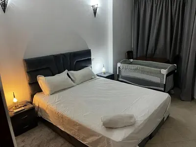 a bedroom with a large bed and a chair at Perfect only family apartment & air cooling in Marrakech