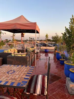 a table and chairs under an umbrella on a patio at Appartment Khadija in Marrakech