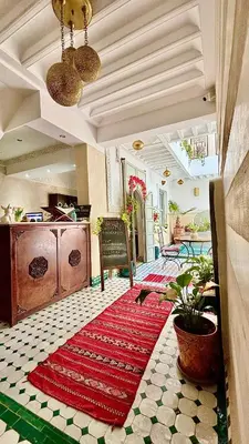 a living room with a red rug on a floor at Riad Magnolia&SPA in Marrakech