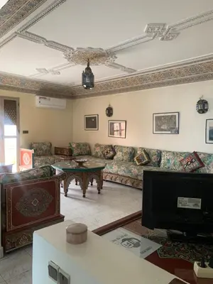 a living room with a couch and a table at APPARTEMENT PERLE RARE AU CENTRE DE MARRAKECH in Marrakech