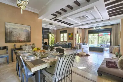 a dining room and living room with a table and chairs at VILLA Garden in Marrakech