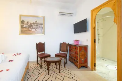 a bedroom with a bed and two chairs and a desk at Riad El Habib in Marrakech