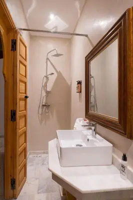 a bathroom with a white sink and a mirror at Riad El Habib in Marrakech