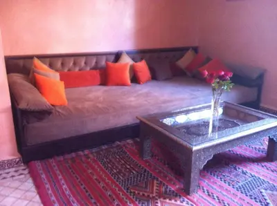 a large bed with orange and orange pillows and a table at Villa Aalama in Marrakech