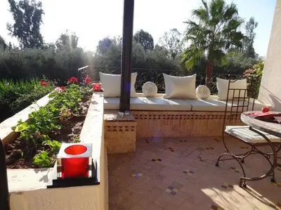 a bench sitting on a patio with a garden at Villa Aalama in Marrakech