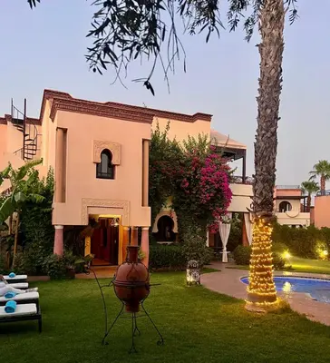 a house with a palm tree in the yard at Villa Aalama in Marrakech