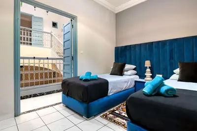 two beds in a room with a balcony at Très Beau Riad à Marrakech avec piscines in Marrakech