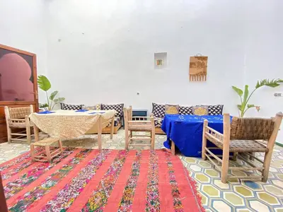 a room with a table and chairs and a rug at house rose in Marrakech