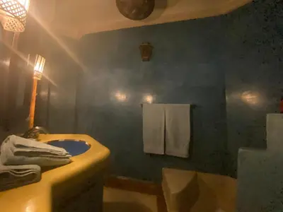 a bathroom with a sink and a toilet and towels at Riad Sabah in Marrakech