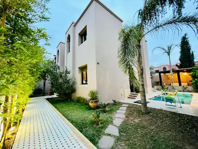 a villa with a swimming pool and a house at SABOR VILLA TARGA GARDEN -Only Family in Marrakech