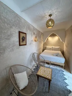a bedroom with a bed and a table and chairs at Riad Yu Yu in Marrakech