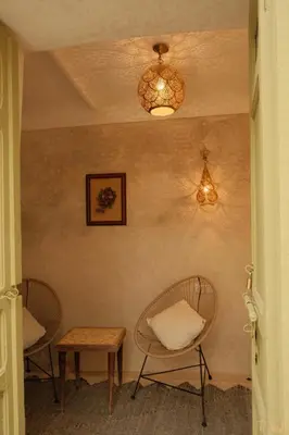 a hallway with two chairs and a table and lights at Riad Yu Yu in Marrakech