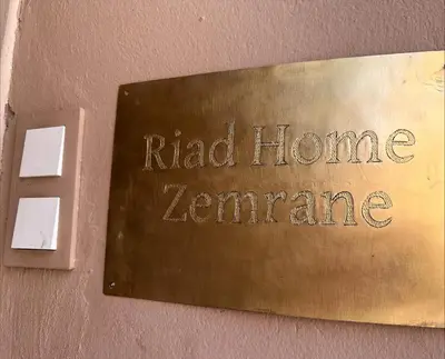 a metal sign on a wall with the words raid homearma at Riad Home Zemrane in Marrakech