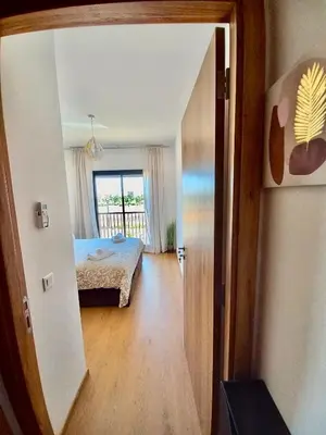 a room with a bed and a door leading to a bedroom at Magnifique appartement Résidence DOMAINE DE NORIA in Marrakech