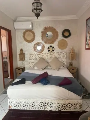 a bedroom with a large bed with mirrors on the wall at Riad Palmier fleuri in Marrakech