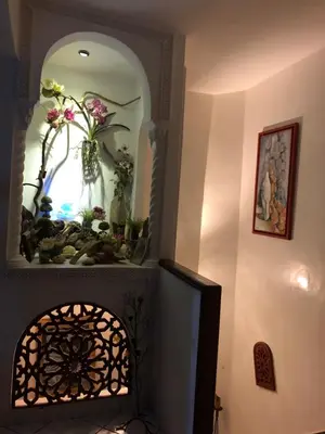 a room with a mirror and a vase with flowers at Riad Palmier fleuri in Marrakech
