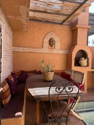 an outdoor patio with a table and a couch at Riad Palmier fleuri in Marrakech