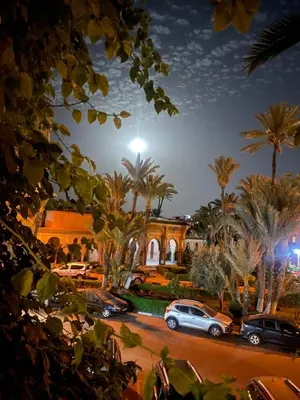 a house with cars parked in a parking lot at Riad Palmier fleuri in Marrakech