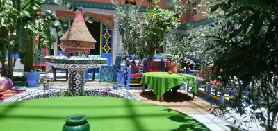 a table with a green table cloth in a garden at Riad Carole - Perfect for Families & Groups in Marrakech