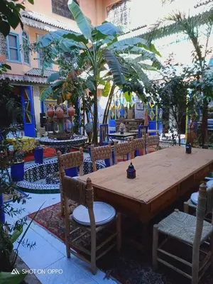 a wooden table and chairs in a courtyard at Riad Carole - Perfect for Families & Groups in Marrakech