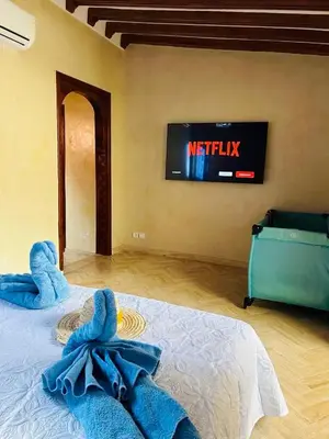a bedroom with a bed with a tv on the wall at RIAD ZAKARYA in Marrakech