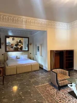 a bedroom with a large bed and a fireplace at Riad Palais Didier Six in Marrakech