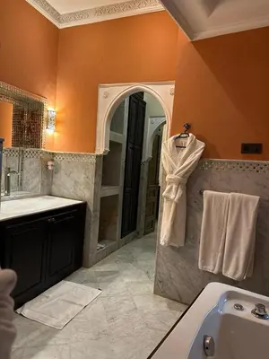 a bathroom with a tub and a sink and a mirror at Riad Palais Didier Six in Marrakech