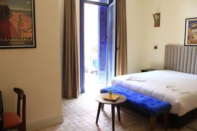 a hotel room with a bed and a blue bench at Comfy Colonial Apartments in Marrakech