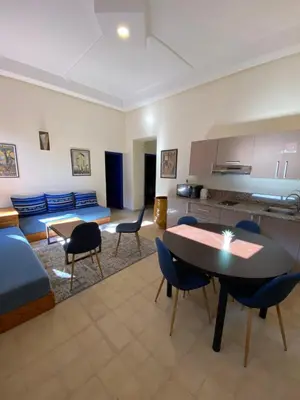 a living room with a couch and a table and chairs at Comfy Colonial Apartments in Marrakech
