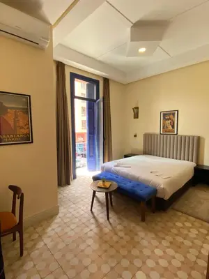 a bedroom with a bed and a table in it at Comfy Colonial Apartments in Marrakech