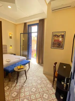 a hotel room with a bed and a table at Comfy Colonial Apartments in Marrakech