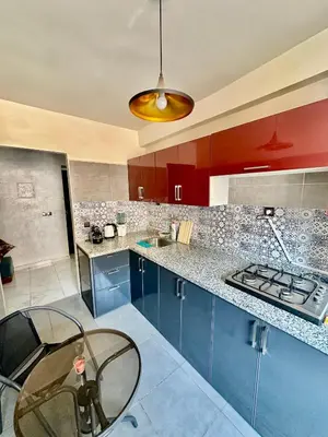 a kitchen with blue cabinets and a glass table at Lovely 2-bedroom appartement in Marrakech